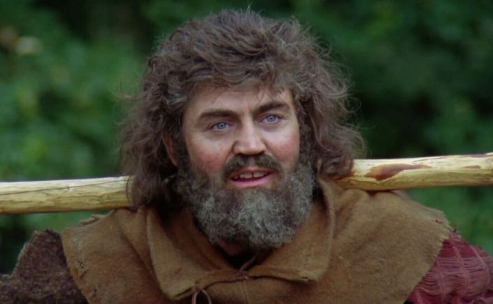 Little John from the film Robin Hood: Prince of Thieves. He has a thick bushy beard and wears a tunic.